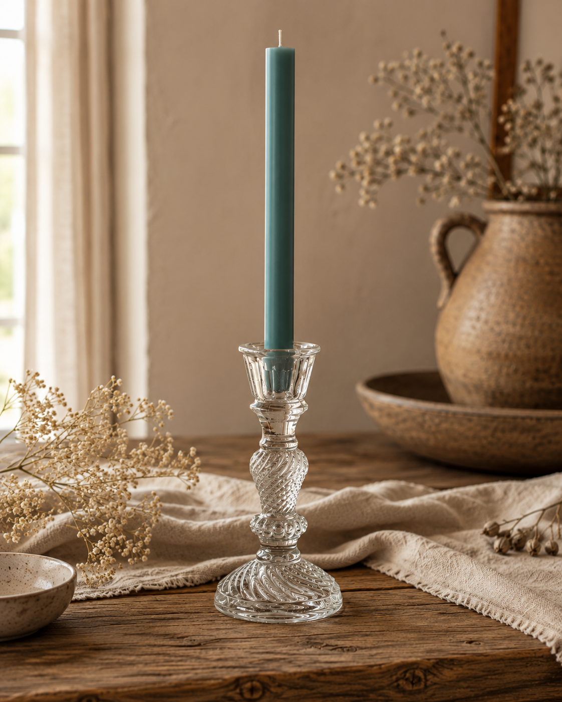 Frostgrüne Flachkopf-Stabkerze im dekorativen Glas-Kerzenhalter Liv auf rustikalem Holztisch im warmen Farmhouse-Stil.