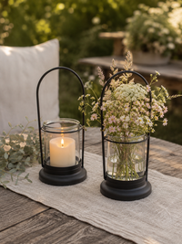 Schwarze Laterne Liva mit Kerze und Blumen auf einem rustikalen Tisch