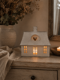 Lichthaus Lotta mit warmem Teelicht auf einer Holzkommode dekoriert